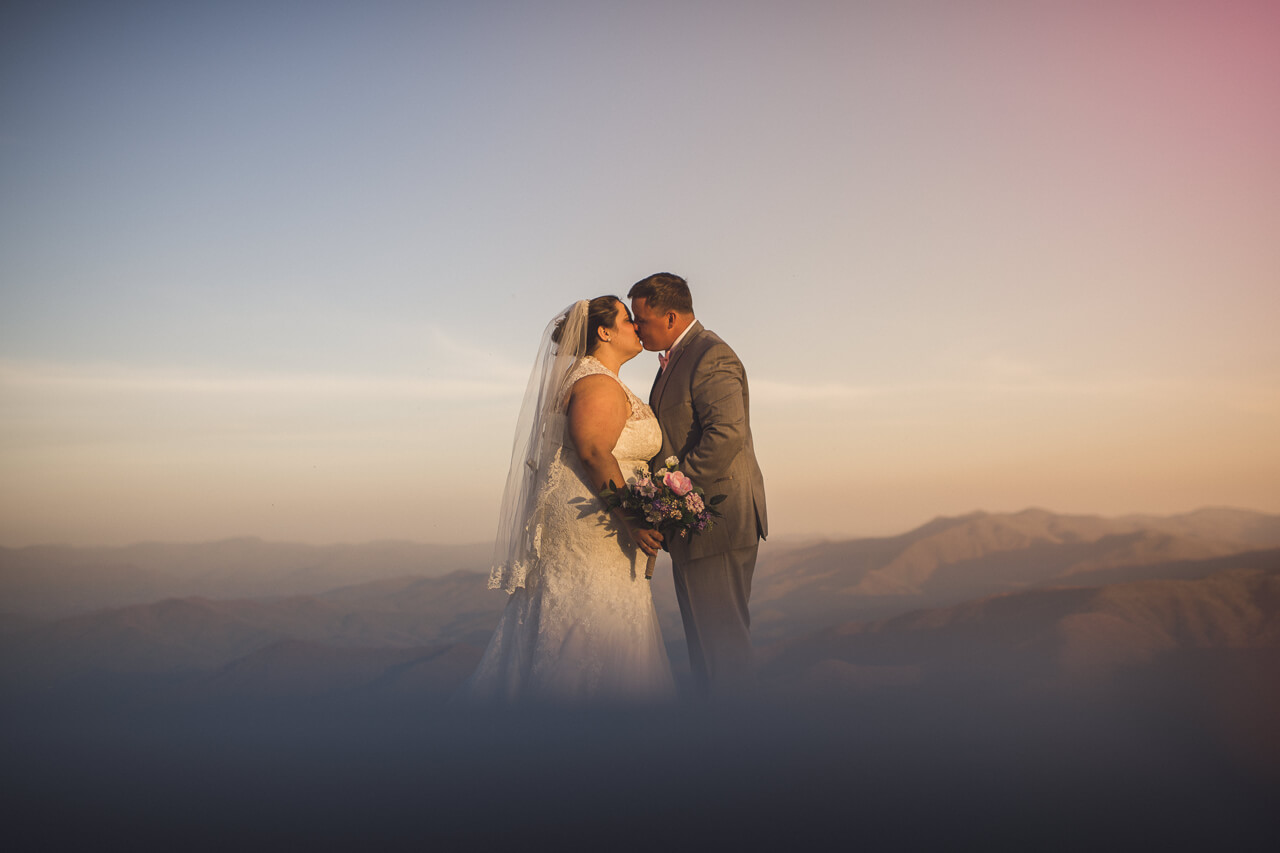 Wedding couple at Wayah Bald in the Blue Hour as couple seems to float upon the panoramic mountain view skyline