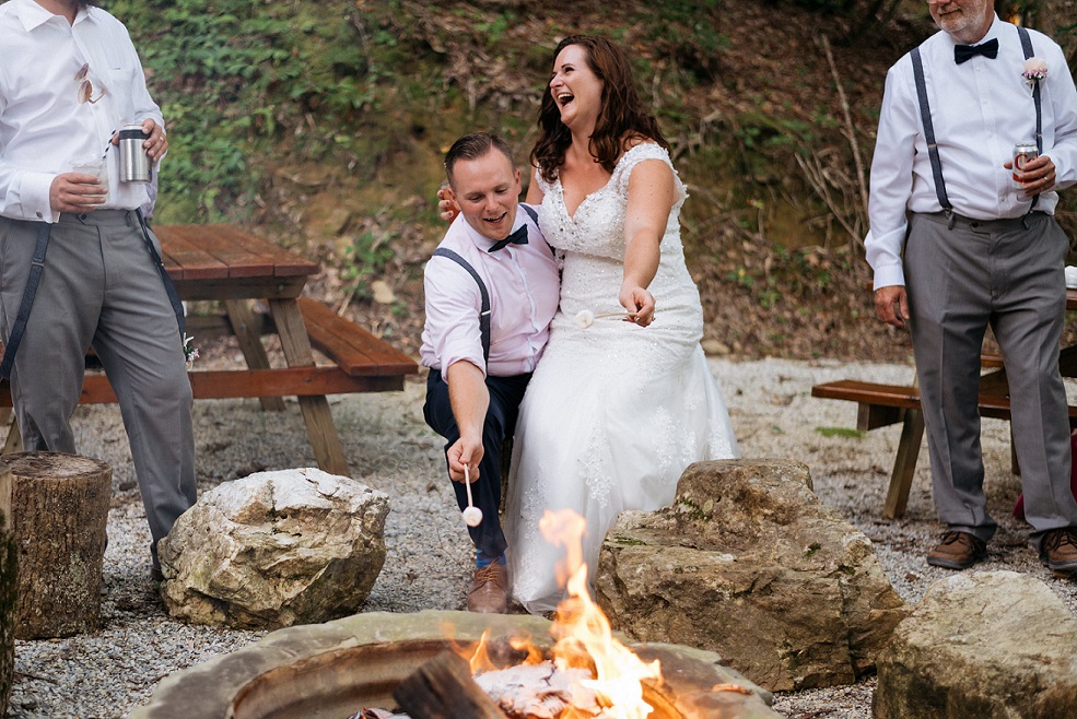 Bride and groom toasting marshmallows at whimsical outdoor wedding venue in NC Mountains